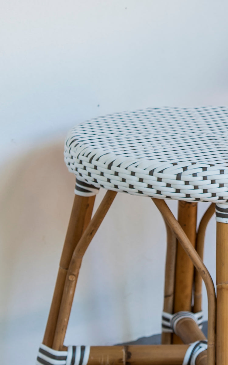 Dies ist ein Nahaufnahmebild von Simone Hocker in white w cappuccino dot ArtFibre Skin on Rattan frame. Detail des gepunkteten Geflechts.