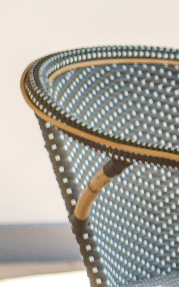 Dies ist ein Nahaufnahmebild von Madeleine Esszimmerstuhl in cappuccino w white dot rattan frame. Strukturiertes Punktgeflecht in warmen Tönen.