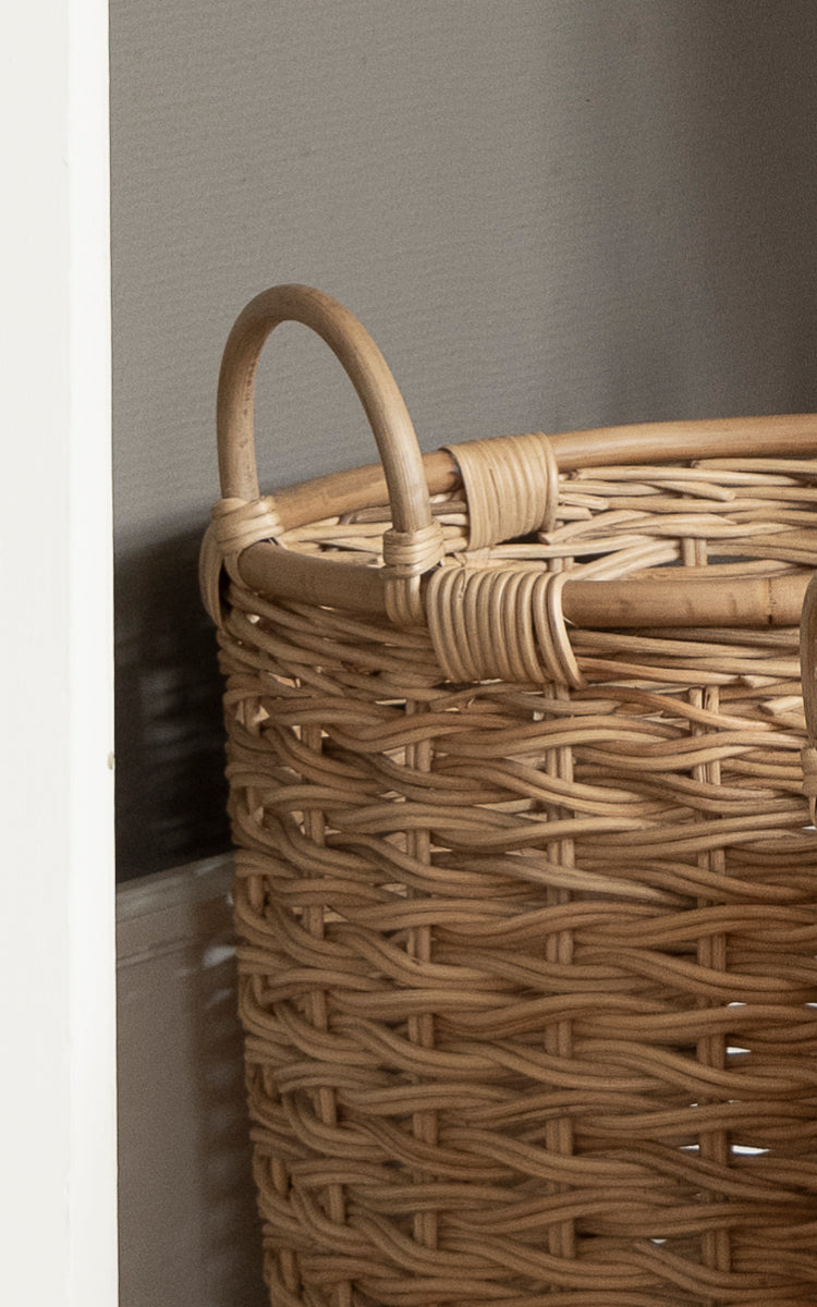 Dies ist ein Nahaufnahmebild von Sarah Korb-Set in natural rattan. Detail des geflochtenen Rattangriffs und des kräftig geflochtenen Korbkörpers.