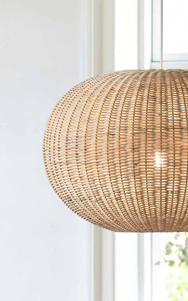 Dies ist ein Nahaufnahmebild von Tangelo Lampshade Ø62 cm | Large in natural rattan. Detail des großen Rattangeflechts des abgerundeten Pendels am Fenster.