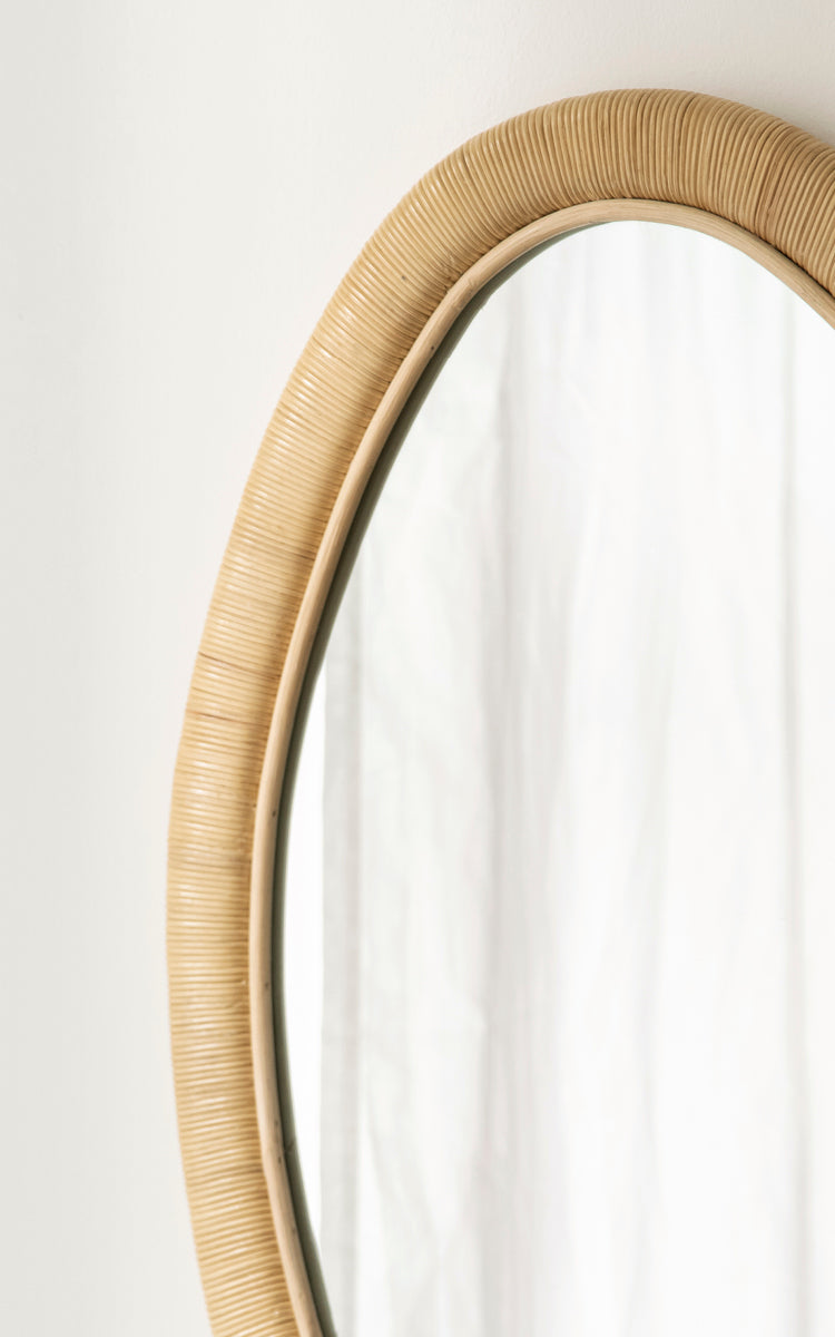Dies ist ein Nahaufnahmebild von Malou Spiegel in natural rattan. Umwickelter Rattanrahmen mit organischer ovaler Form und weichem Licht.