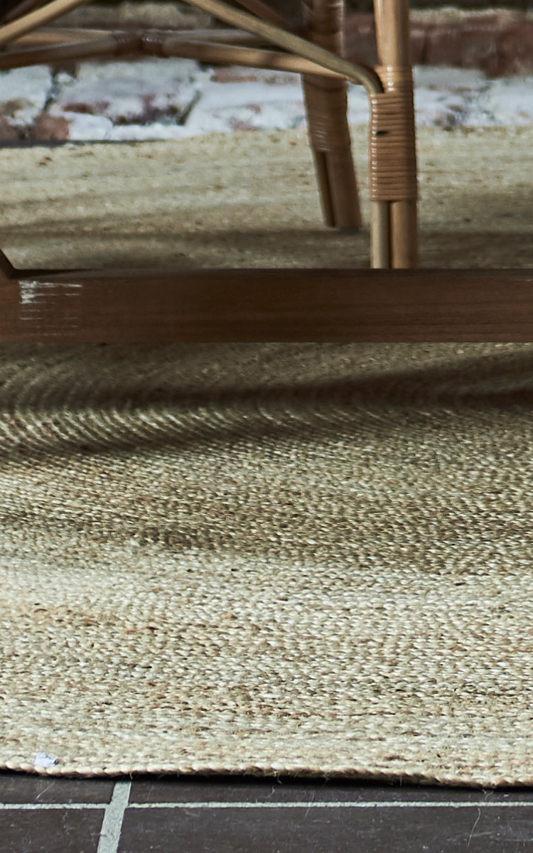 Dies ist ein Nahaufnahmebild von Jute Carpet Ø280 in natural jute. Das eng gewebte konzentrische Muster und der natürliche Rand zeigen den runden Teppich.