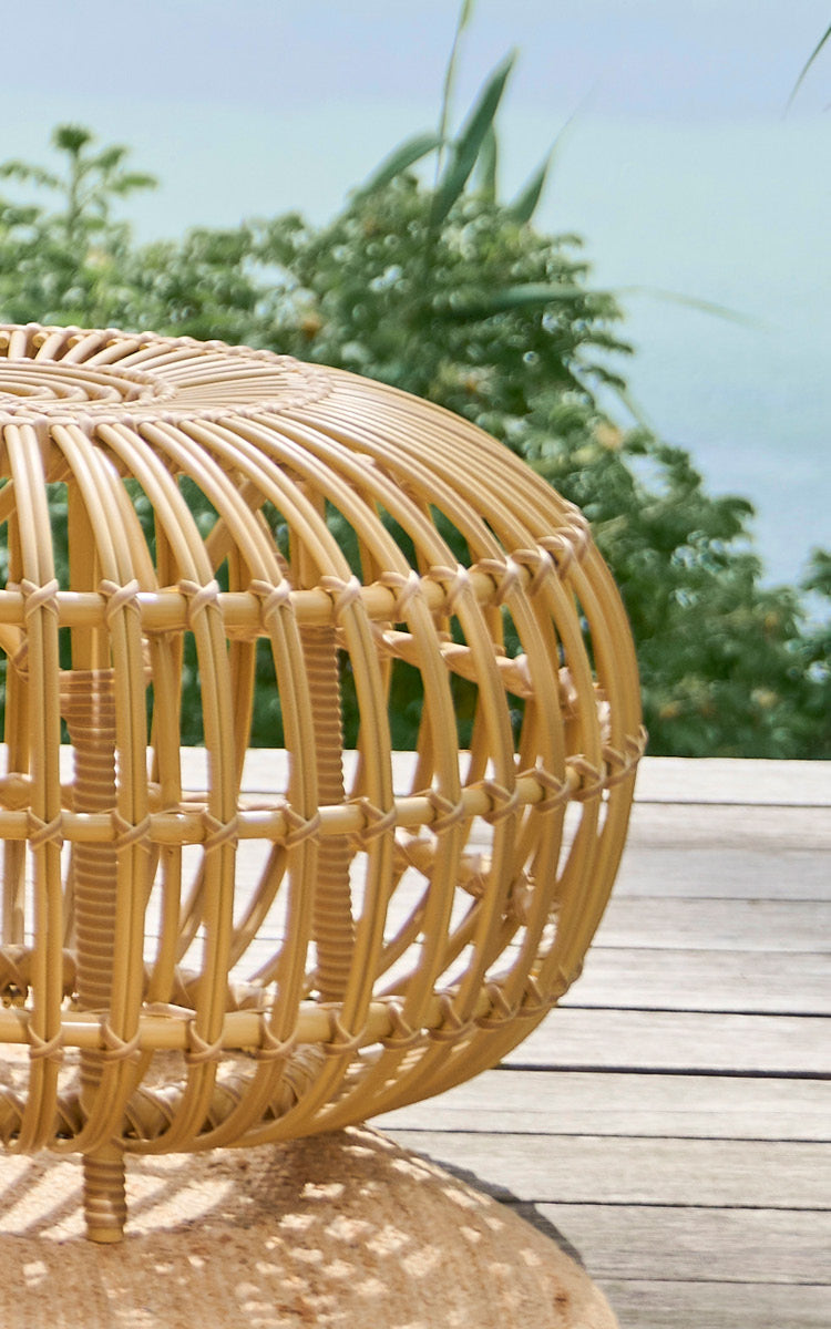 Dies ist ein Nahaufnahmebild von FA-E16-NU Ottoman Exterior in natural aluminium artfibre. Detail des geflochtenen ArtFibre-Ottomans mit gebogenen Rippen auf einer Terrasse.