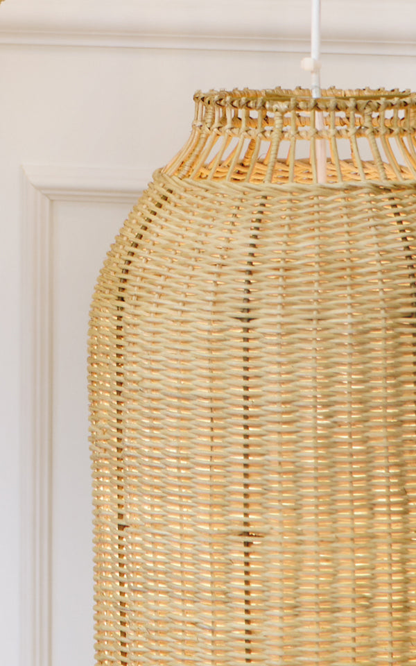 Dies ist ein Nahaufnahmebild von Kou Lampenschirm in natural core weave rattan frame. Die eng gewebte Laternenform und das warme Leuchten sind hervorgehoben.
