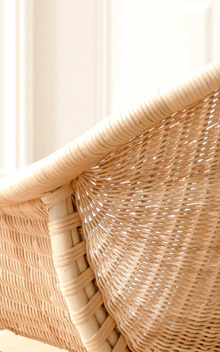 Dies ist ein Nahaufnahmebild von Madame Lounge-Sessel in natural core weave rattan frame. Fein geflochtene Rattan-Rückenlehne im weichen Licht.