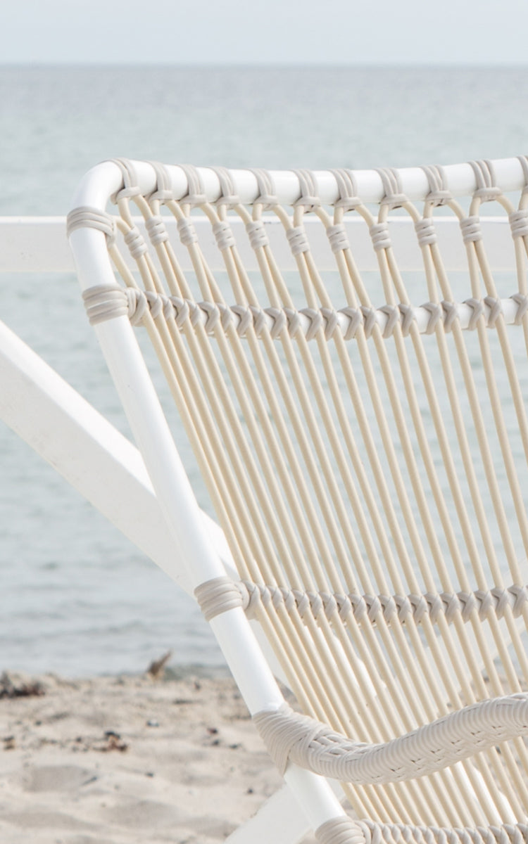 Dies ist ein Nahaufnahmebild von Monet Exterior Rocking Chair i dove white aluminium artfibre. Detail der Schlaufenbogen-Rückenlehne.