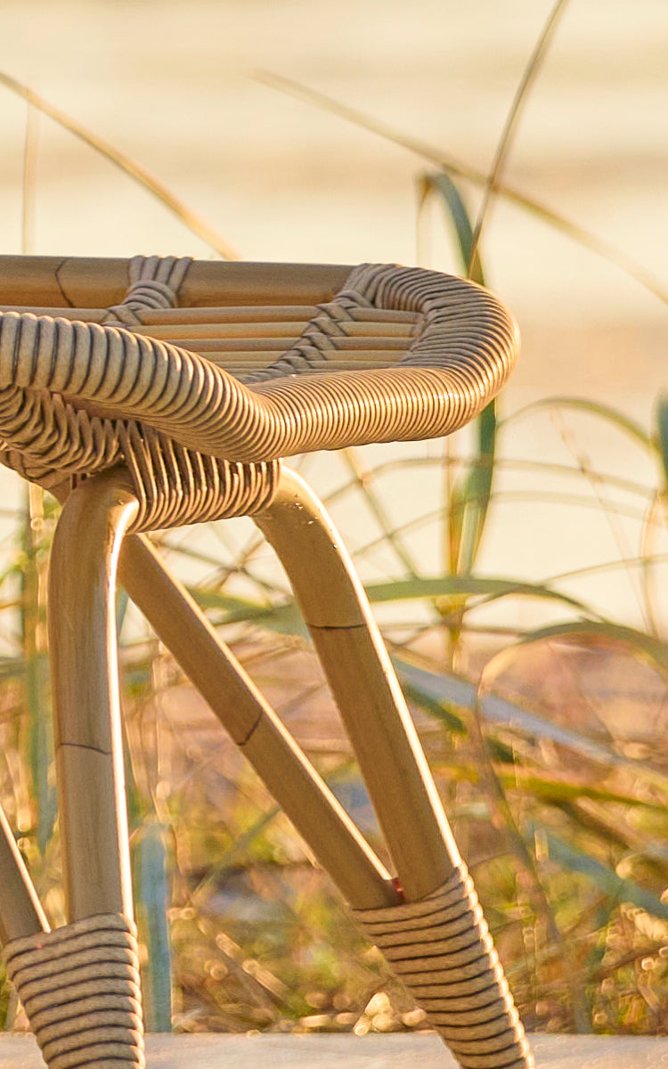 Dies ist ein Nahaufnahmebild von Monet Exterior Footstool i antique aluminium artfibre. Detail der geflochtenen ArtFibre-Sitzfläche.