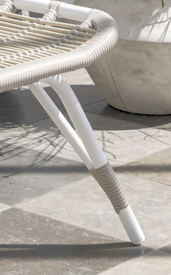 Dies ist ein Nahaufnahmebild von Monet Exterior Footstool i dove white aluminium artfibre. Detail des geflochtenen Sitzes und des weißen Gestells.