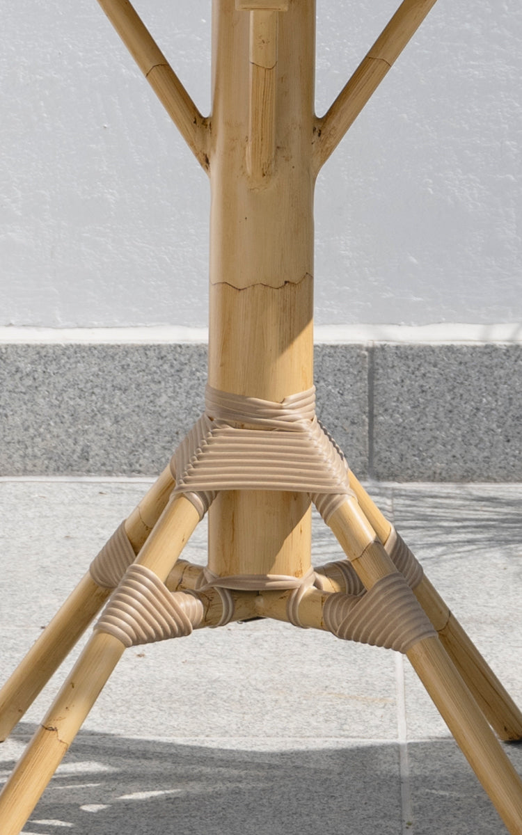 Dies ist ein Nahaufnahmebild von Nicole Cáfe Table Teak 70x70 cm in natural aluminium artfibre. Detail der geflochtenen Textur und Rahmenkonstruktion.