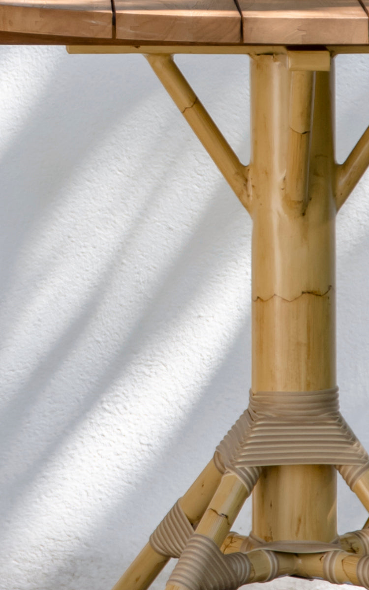 Dies ist ein Nahaufnahmebild von Nicole Cáfe Table | Teak Ø80 cm in natural aluminium artfibre. Detail der geflochtenen Textur und Rahmenkonstruktion.
