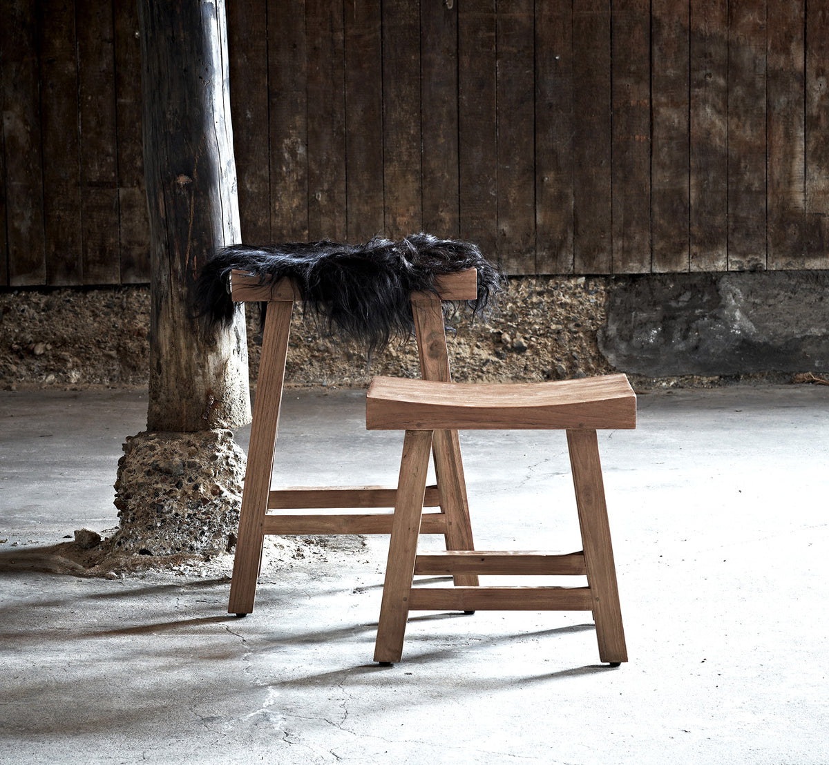 Dies ist ein Lifestyle-Bild von Charles Hocker in teak indoor, in einem hell-weißen Interieur mit Wandvertäfelung und Fischgrätparkett.
