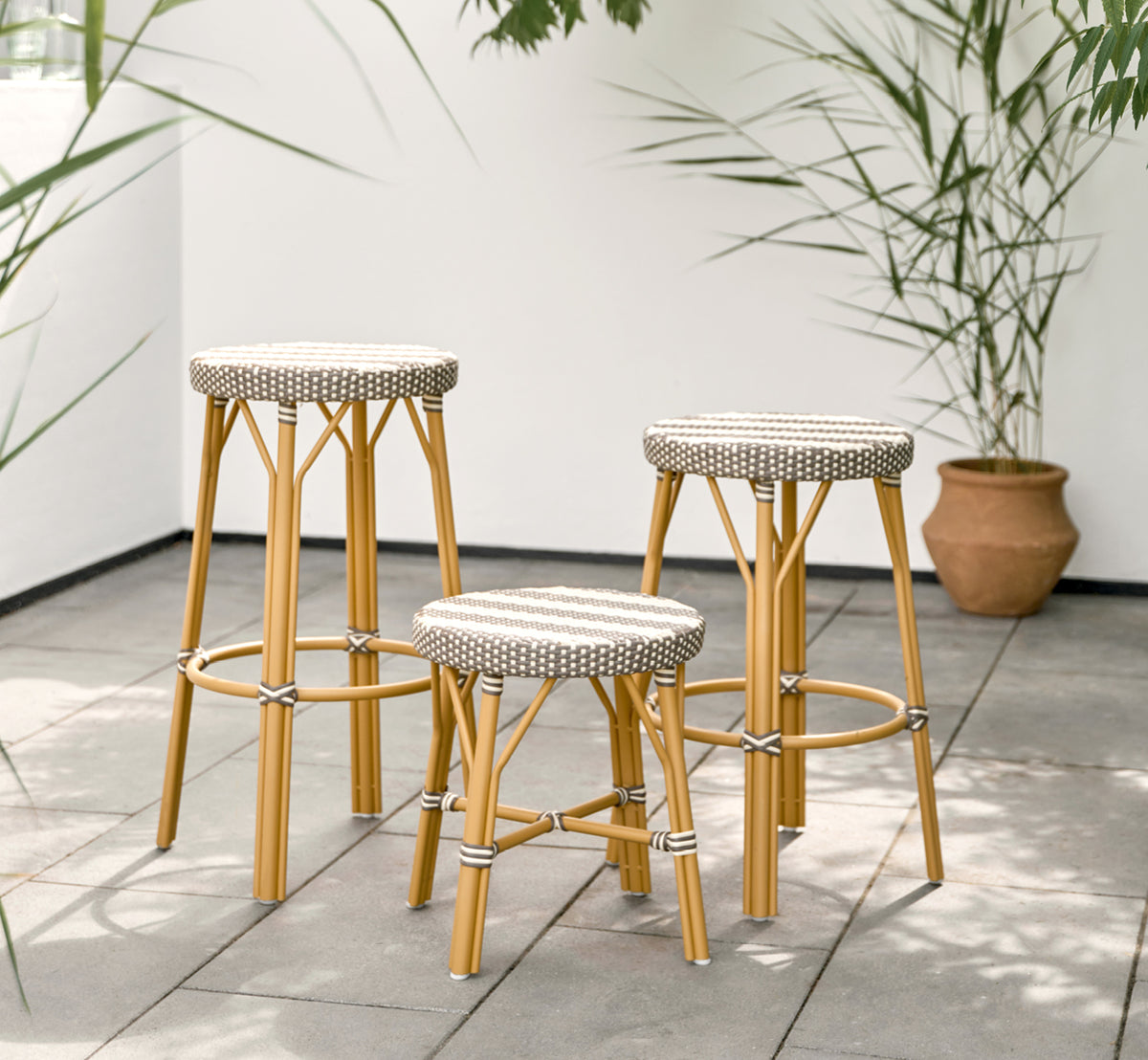 Dies ist ein Lifestyle-Bild von Simone Außen-Hocker in almond aluminium frame striped cappuccino ivory artfibre. In einem hellen Interieur gestylt.