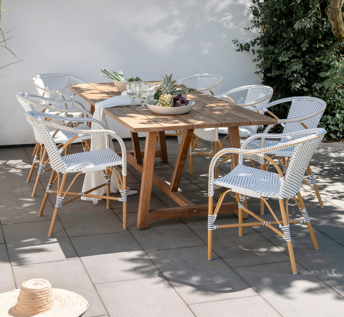 Dies ist ein Lifestyle-Bild von Madeleine Außen-Esszimmerstuhl in almond aluminium frame white w cappuccino dot ArtFibre. Gartenessen mit Teaktisch.