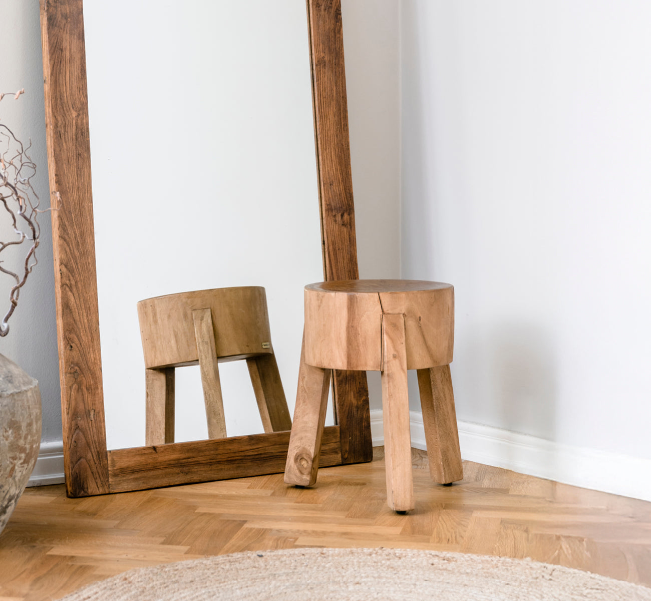 Dies ist ein Lifestyle-Bild von Roger Hocker in teak indoor. An einem Holzschreibtisch mit Lampe und Pflanze in einem hellen Fischgrät-Arbeitszimmer platziert.