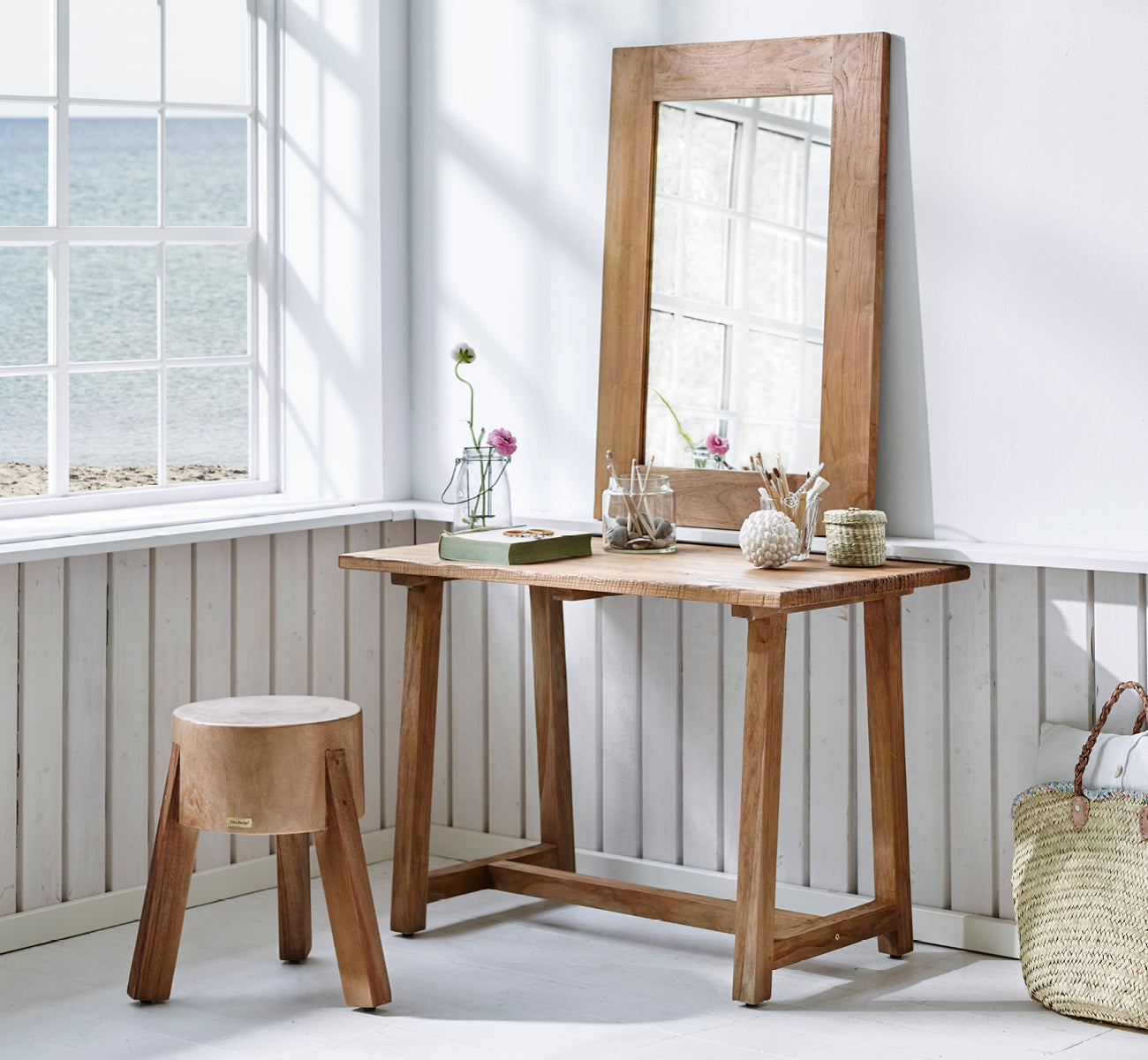 Dies ist ein Lifestyle-Bild von Roger Hocker in teak indoor. An einem Holzschreibtisch mit Lampe und Pflanze in einem hellen Fischgrät-Arbeitszimmer platziert.