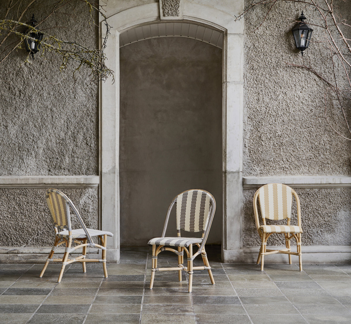 Dies ist ein Lifestyle-Bild von Sofie Esszimmerstuhl in striped grey ivory artfibre skin on rattan frame. In einem hellen Interieur gestylt.
