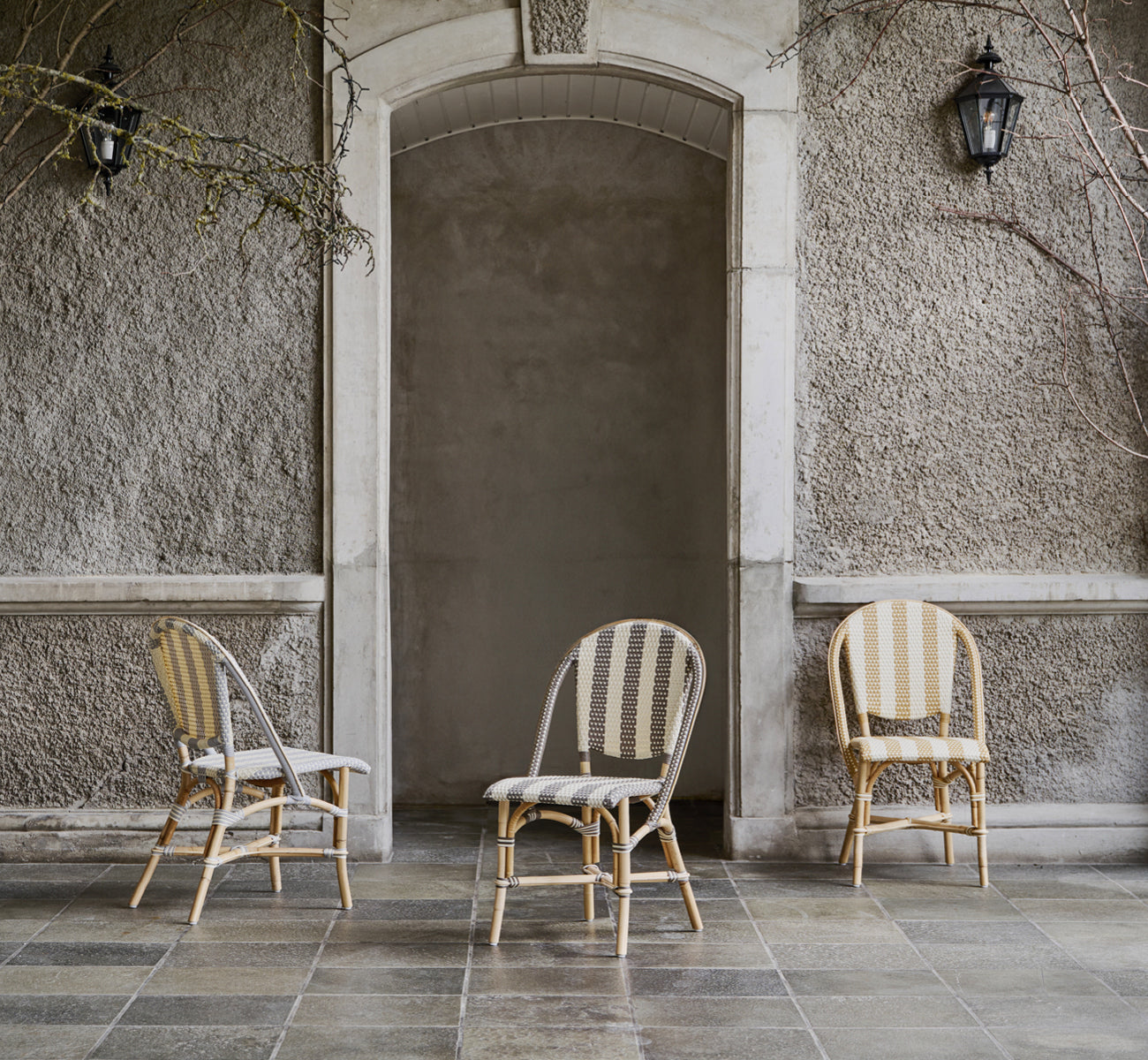 Dies ist ein Lifestyle-Bild von Sofie Esszimmerstuhl in striped grey ivory artfibre skin on rattan frame. In einem hellen Interieur gestylt.