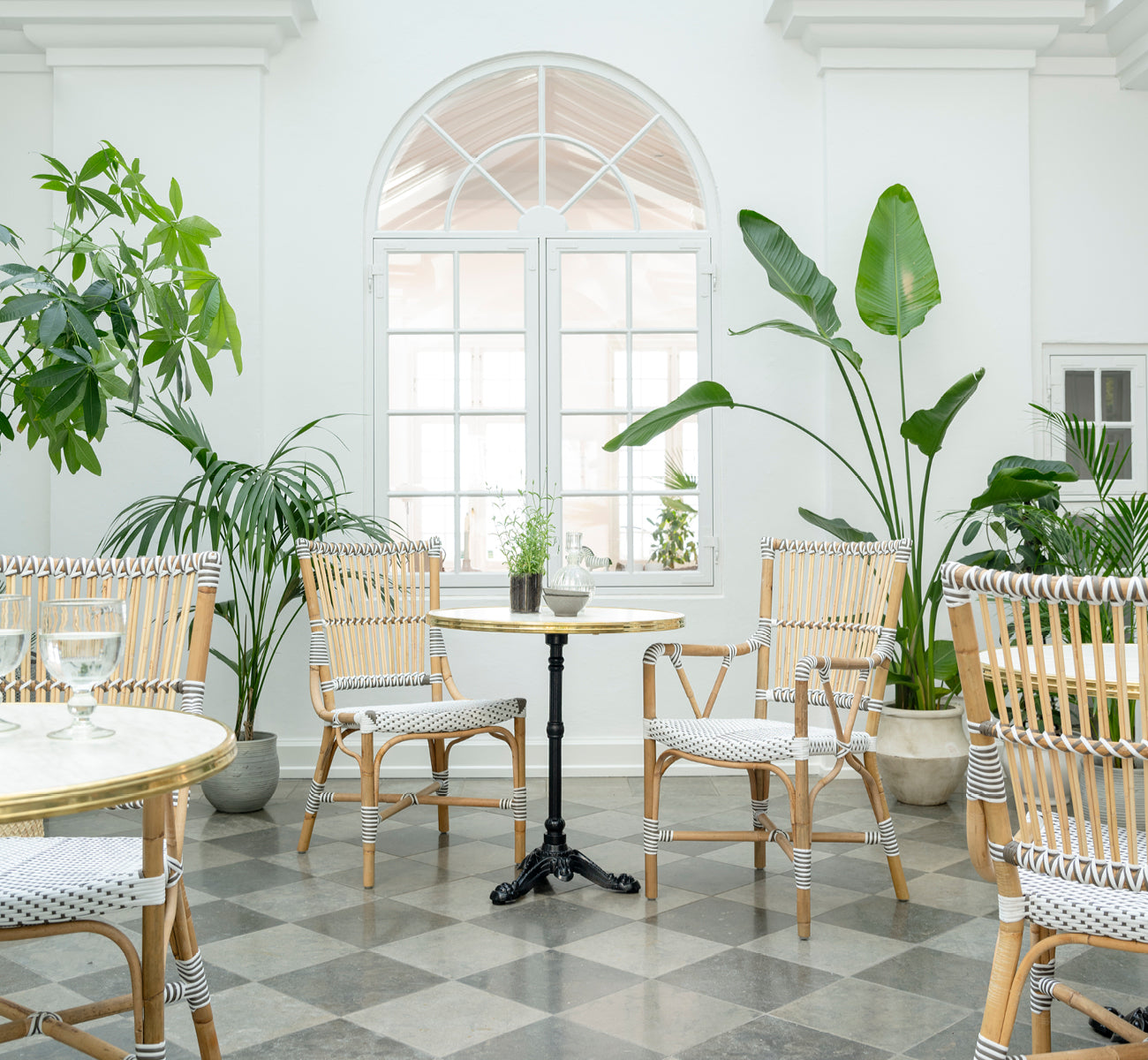 Dies ist ein Lifestyle-Bild von Monique Esszimmerstuhl in white w cappuccino dot artfibre skin on rattan frame. In einem hellen Interieur gestylt.