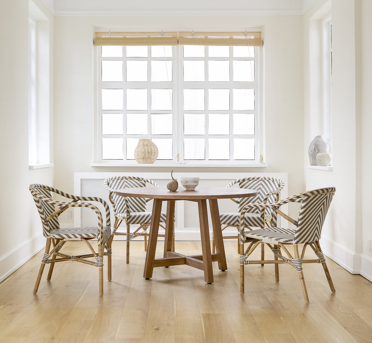 Dies ist ein Lifestyle-Bild von Madeleine Esszimmerstuhl in chevron cappuccino ivory ArtFibre skin on rattan frame. Weißes Esszimmer mit Eichenboden.