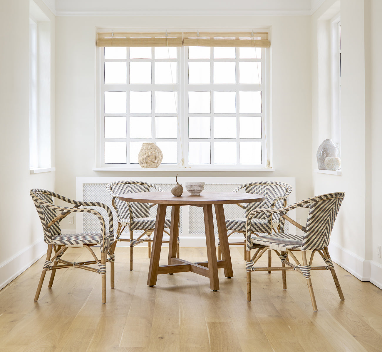 Dies ist ein Lifestyle-Bild von Madeleine Esszimmerstuhl in chevron cappuccino ivory ArtFibre skin on rattan frame. Weißes Esszimmer mit Eichenboden.