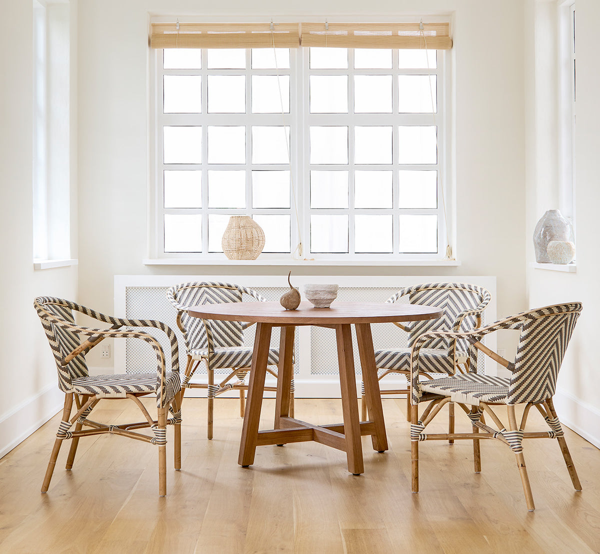 Dies ist ein Lifestyle-Bild von Aksel Esstisch in teak indoor, in einem hellen Essbereich mit großen Fenstern und hellem Holzboden.