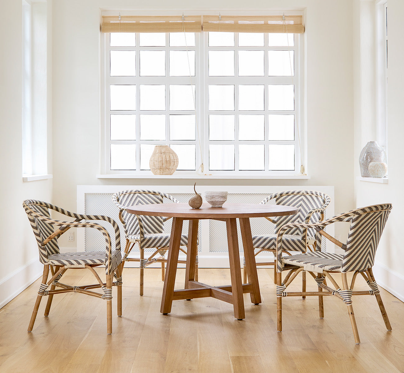 Dies ist ein Lifestyle-Bild von Aksel Esstisch in teak indoor, in einem hellen Essbereich mit großen Fenstern und hellem Holzboden.