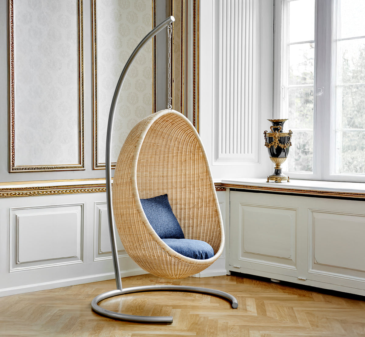 Dies ist ein Lifestyle-Bild von Stand Hängesessel in metal stand, in einem eleganten klassischen Interieur mit aufwändigen goldenen Stuckleisten.