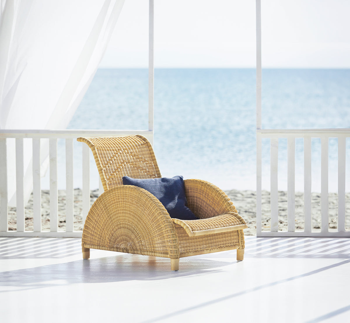Dies ist ein Lifestyle-Bild von Paris Außen-Lounge-Sessel in natural core weave artfibre aluminium. In einem hellen Interieur gestylt.