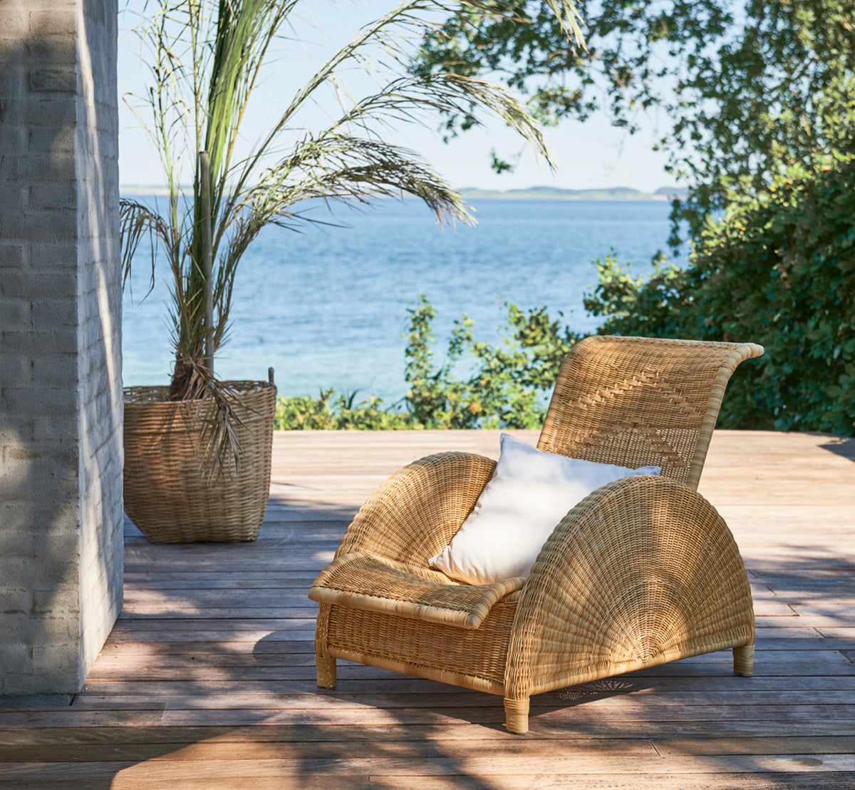 Dies ist ein Lifestyle-Bild von Paris Außen-Lounge-Sessel in natural core weave artfibre aluminium. In einem hellen Interieur gestylt.