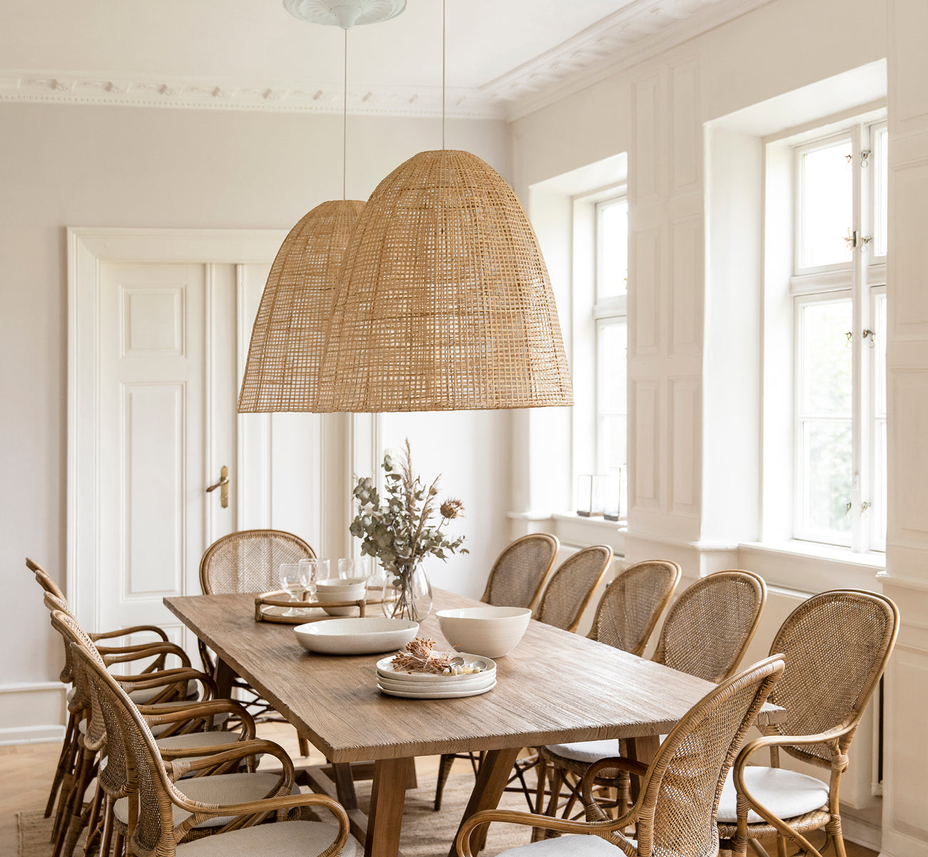 Dies ist ein Lifestyle-Bild von Showroom Lampenschirm in natural core weave artfibre & aluminium. Über einem gedeckten Esstisch in einem hellen Raum hängend.
