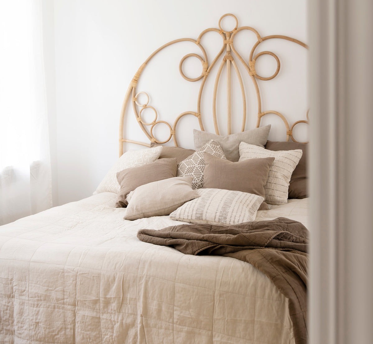 Dies ist ein Lifestyle-Bild von CTE058LA Tagesdecke in latte Cotton, in einem ruhigen Schlafzimmer mit neutraler Einrichtung und Fischgrätparkett.