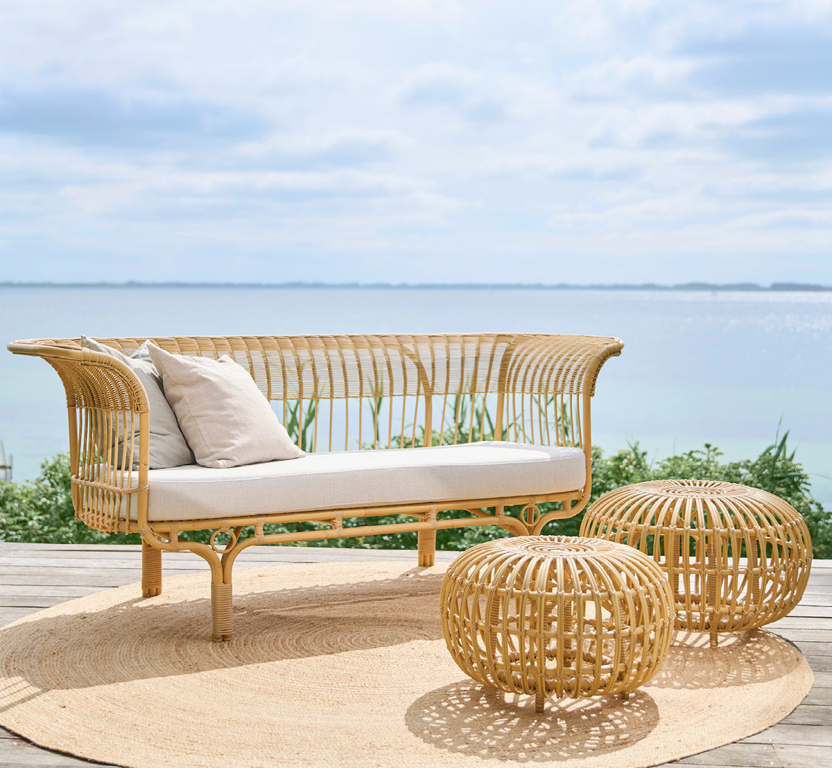 Dies ist ein Lifestyle-Bild von FA-E16-NU Ottoman Exterior in natural aluminium artfibre. In einem hellen Interieur gestylt.