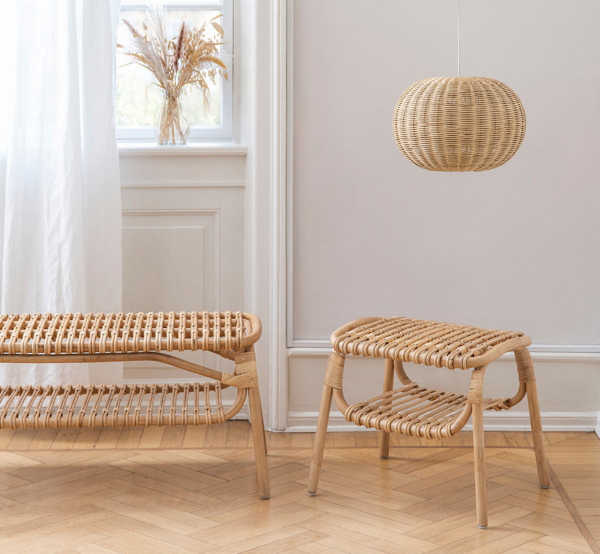 Dies ist ein Lifestyle-Bild von Machiya Bank in natural skin on rattan. Skandinavischer Raum mit Hocker, Pendelleuchte und Pampasgras-Vase.