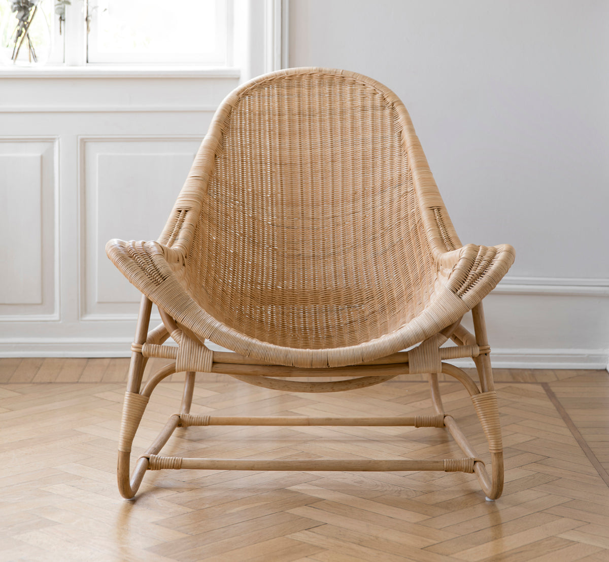 Dies ist ein Lifestyle-Bild von Pacifique Lounge-Sessel in natural core weave rattan frame. In einem hellen Interieur gestylt.