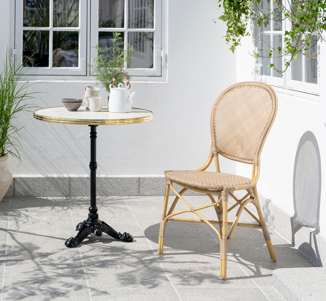Dies ist ein Lifestyle-Bild von Rossini Außen-Esszimmerstuhl in natural aluminium artfibre. In einem hellen Interieur gestylt.