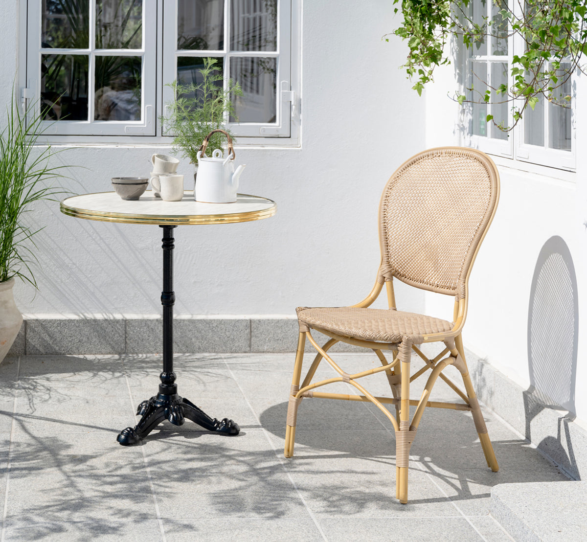 Dies ist ein Lifestyle-Bild von Rossini Außen-Esszimmerstuhl in natural aluminium artfibre. In einem hellen Interieur gestylt.