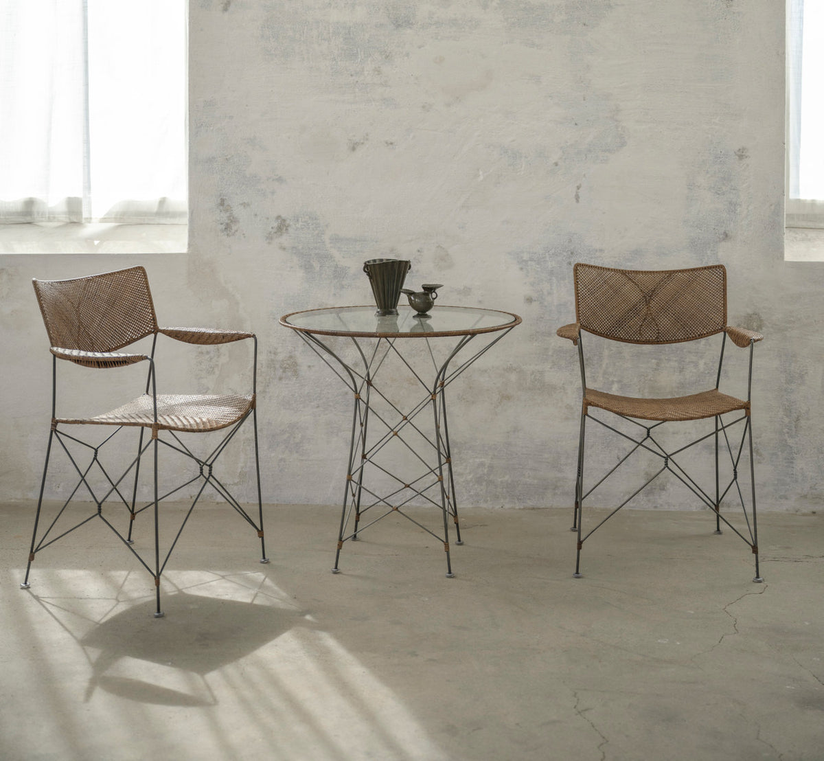 Dies ist ein Lifestyle-Bild von Funky Cafétisch in hazelnut rattan iron frame. Mit Stühlen in einem hellen, sonnigen Raum.