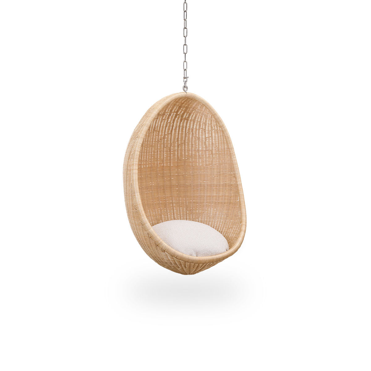 Seitenansicht des Hanging Egg Junior, der Kinderversion des ikonischen Hängesessels, entworfen von Nanna und Jørgen Ditzel. Der runde Hängesessel ist vollständig aus hochwertigem indonesischem Rattan geflochten und hängt an einer Metallkette.