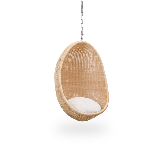 Seitenansicht des Hanging Egg Junior, der Kinderversion des ikonischen Hängesessels, entworfen von Nanna und Jørgen Ditzel. Der runde Hängesessel ist vollständig aus hochwertigem indonesischem Rattan geflochten und hängt an einer Metallkette.