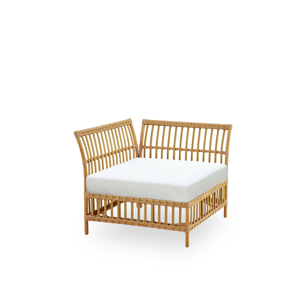 Seitenansicht des Maggie Outdoor-Sofas Eckmodul in Natural-Farbe, präsentiert mit weißem Sitz- und Rückenkissen. Aluminiumrahmen im handbemalten Rattan-Look mit ArtFibre-Umschlingungen.