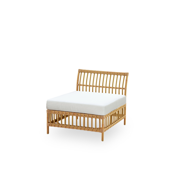 Seitenansicht des Maggie Outdoor-Sofas Mittelmodul in Natural-Farbe, präsentiert mit weißem Sitz- und Rückenkissen. Aluminiumrahmen im handbemalten Rattan-Look mit ArtFibre-Umschlingungen.