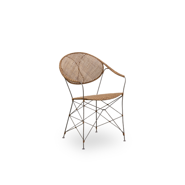 Seitenansicht des Funky Essstuhls, entworfen von Yuzuru Yamakawa. Der Stuhl hat einen Stahlrahmen mit handgeflochtenem Sitz und Rückenlehne aus hochwertigem indonesischem Rattan in Haselnussfarbe.